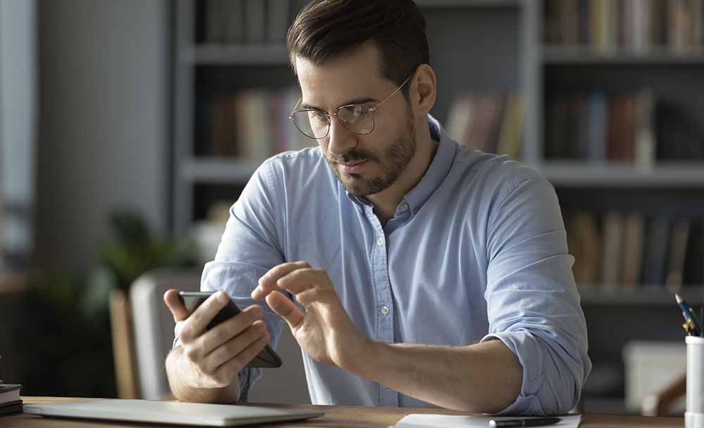 Hombre utilizando y mirando su smartphone