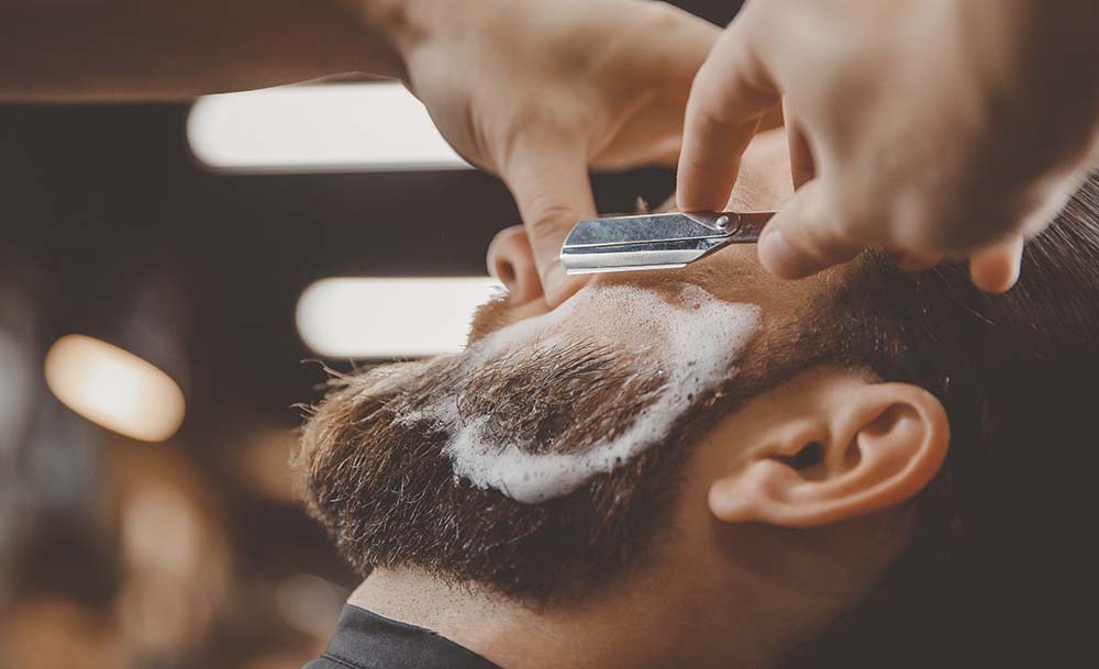Barbero afeitando a un cliente