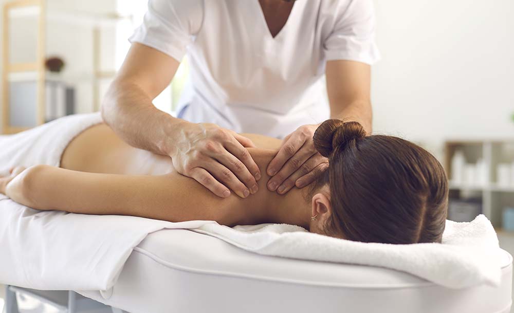 Persona haciendo un masaje en el hombro de una clienta